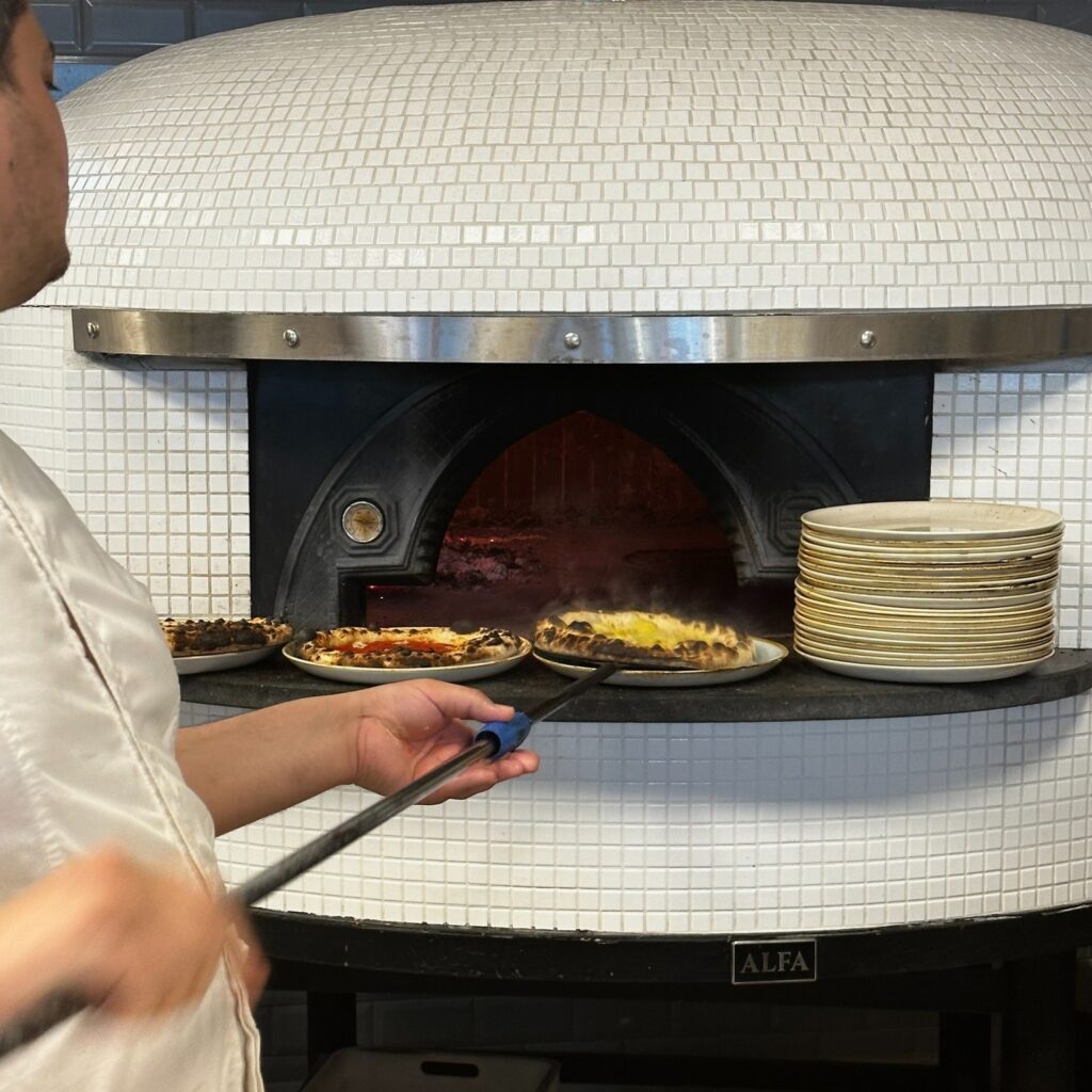 Pizzabager tager pizza ud af stenovn