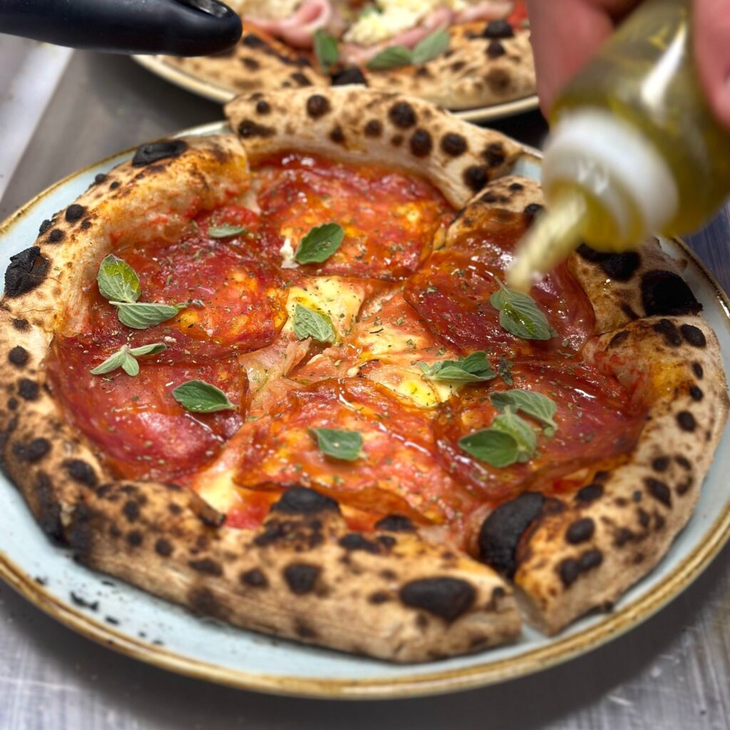 Napolitansk pizza med salami og frisk basilikum