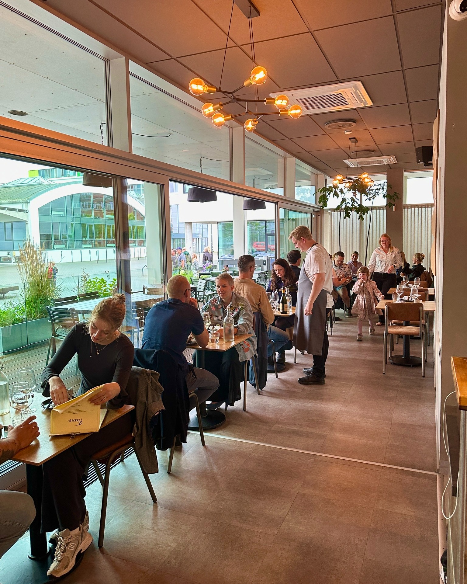 Travl moderne restaurant med gæster ved vinduer