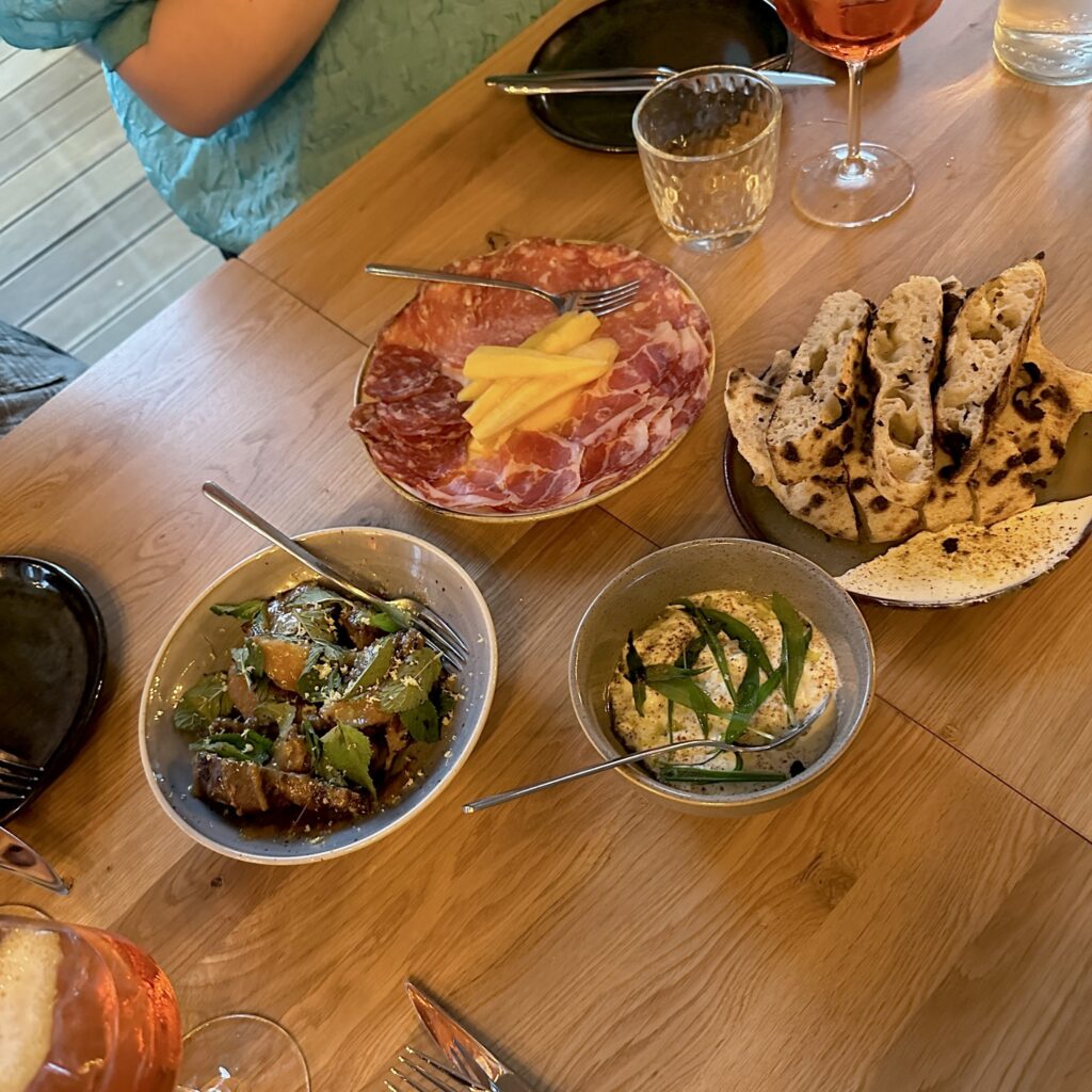 Charcuteri, brød og småretter på træbord