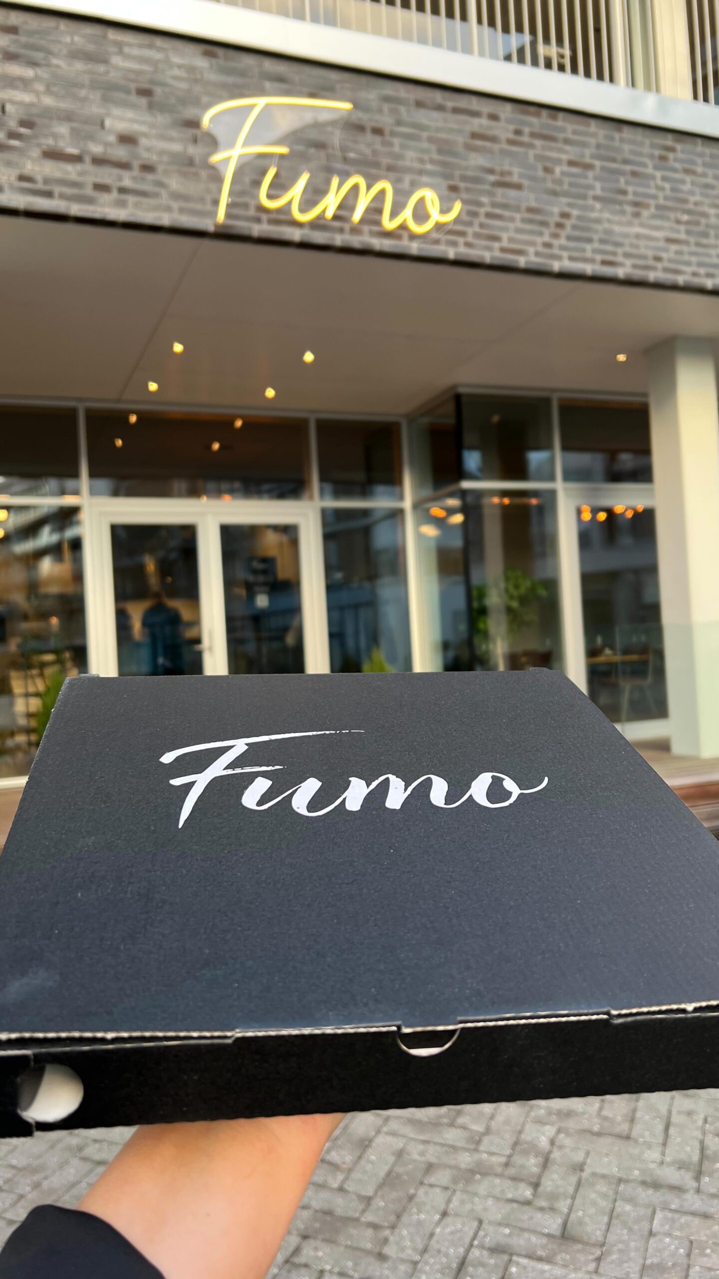 Sort pizzaboks foran restauranten Fumo
