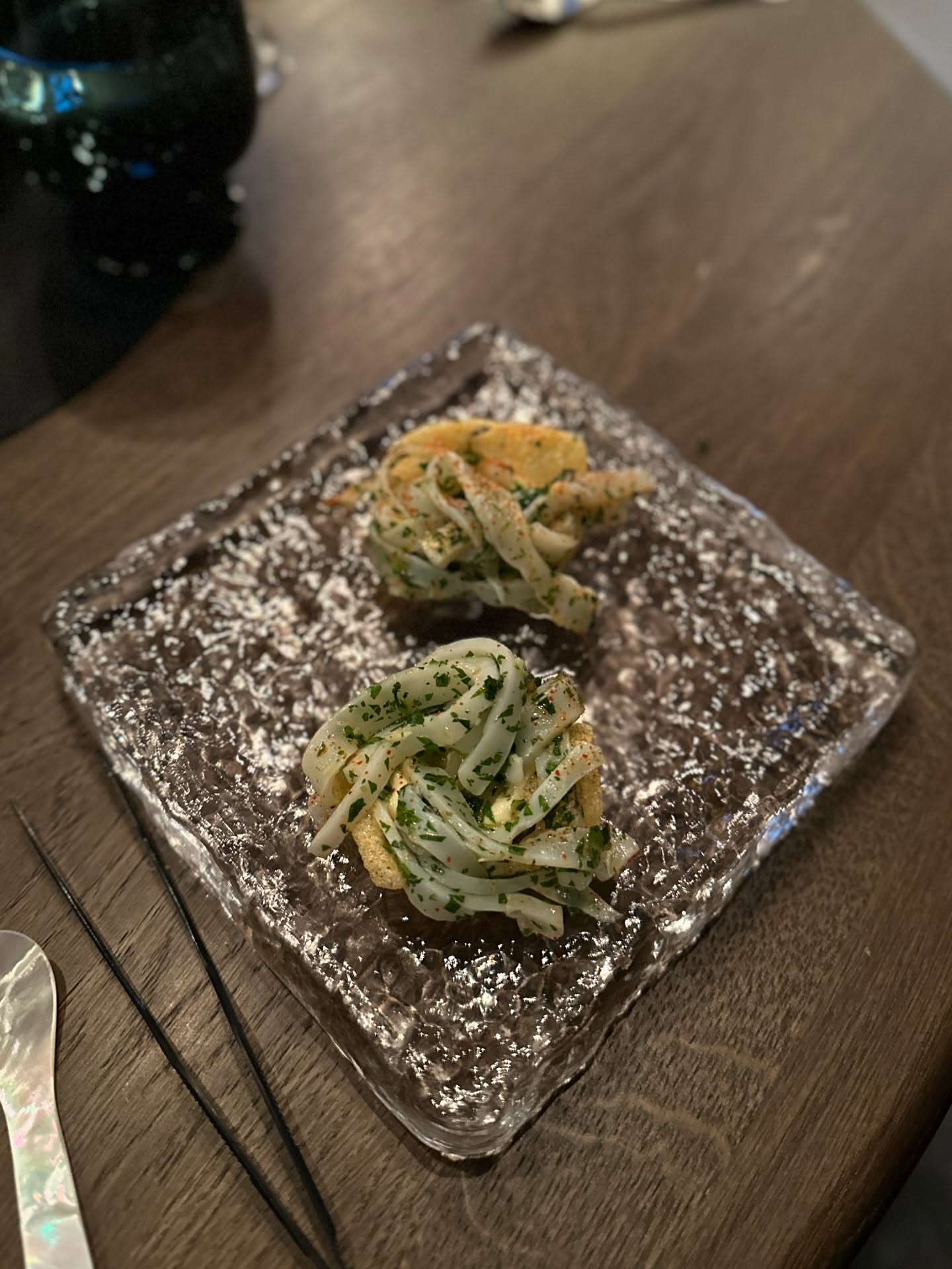 To små appetizers med blæksprutte på glasfad